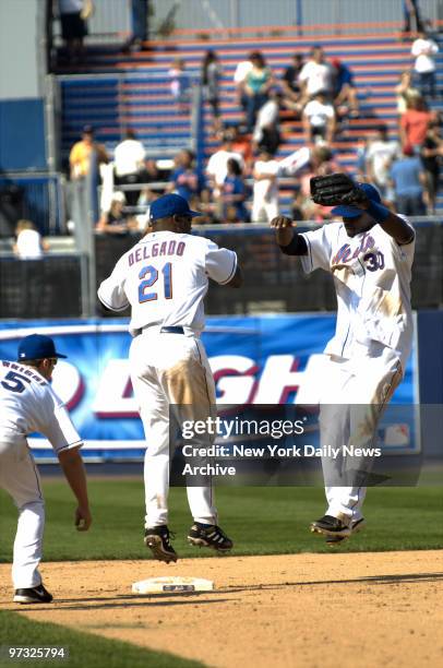 New York Mets' Carlos Delgado and Cliff Floyd leap into the air as they celebrate their 6-5 win over the Atlanta Braves at Shea Stadium.