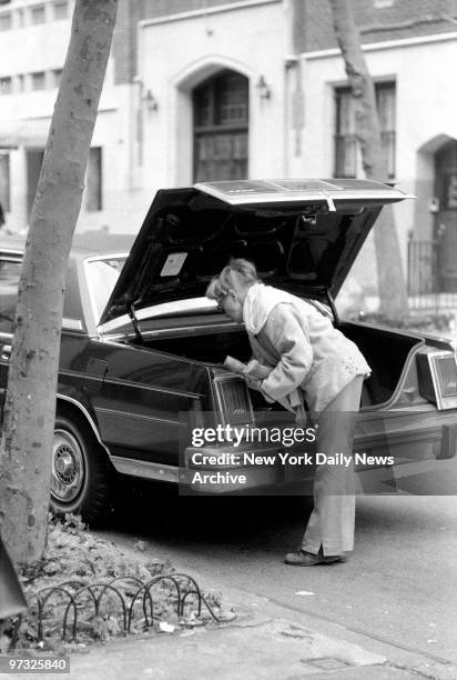 Katherine Hepburn unloads firewood from the trunk of her car outside her E. 49th St. Home.