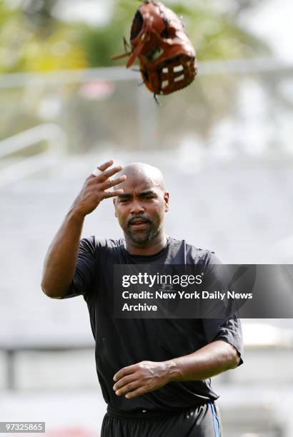 New York Mets' Carlos Delgado flips his glove in the air after fielding drills at Tradition Field during spring training.