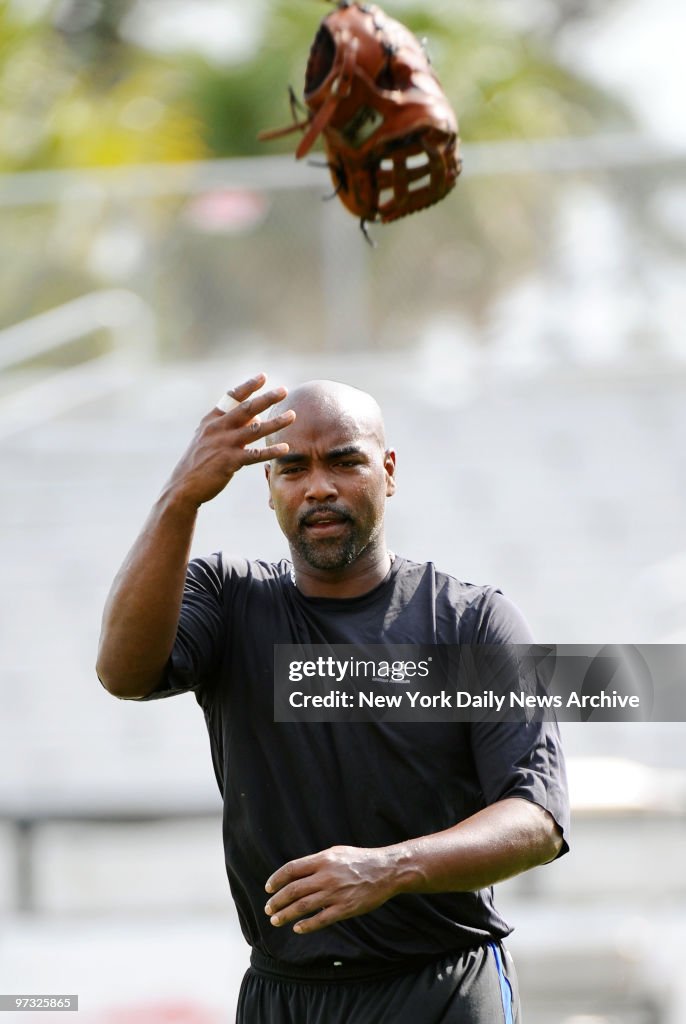 New York Mets' Carlos Delgado flips his glove in the air aft