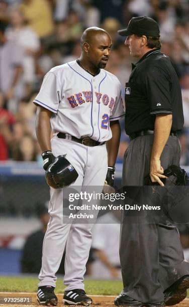 New York Mets' Carlos Delgado gives home plate umpire Tim McClelland a quizzical look after being called out on strikes to end the top of the first...