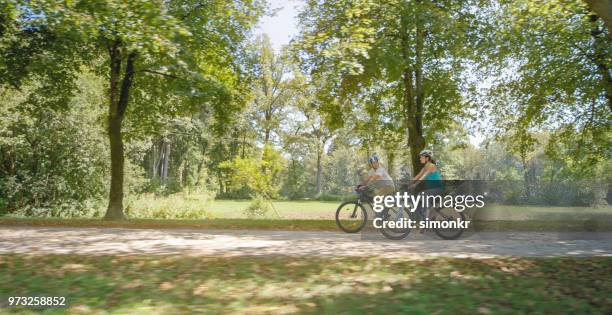 famille de vélo dans le parc - réseau de communication photos et images de collection