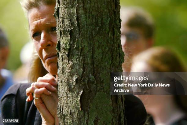 Susan Ellis of Briarcliff Manor stands behind a tree at Kensico Dam Plaza as she holds back tears during the dedication of Westchester County's 9/11...