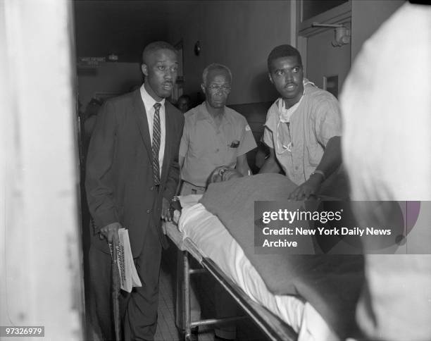 With the letter opener still protruding from his chest, Dr. Martin Luther King is wheeled into Harlem Hospital for treatment after being stabbed.