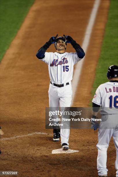 New York Mets' catcher Paul Lo Duca waits to greet center fielder Carlos Beltran, who points up towards the sky as he steps onto home plate, after...