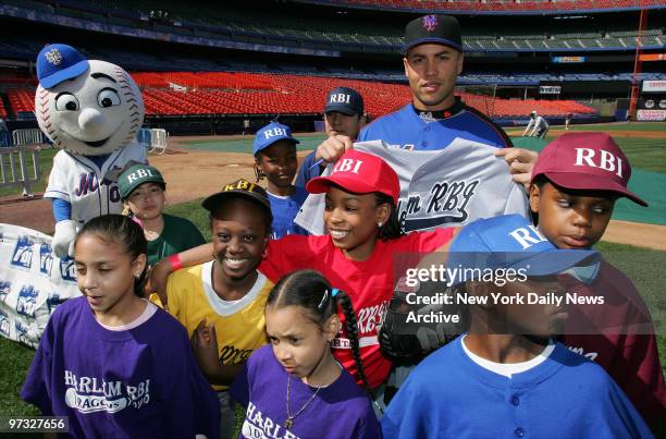 New York Mets' centerfielder Carlos Beltran gets together with members of the Harlem RBI youth baseball league on the field at Shea Stadium, where he...
