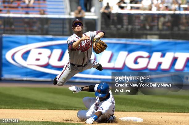 New York Mets' Cliff Floyd is out at second as Atlanta Braves' second baseman Marcus Giles goes horizontal to throw Xavier Nady out at first and...