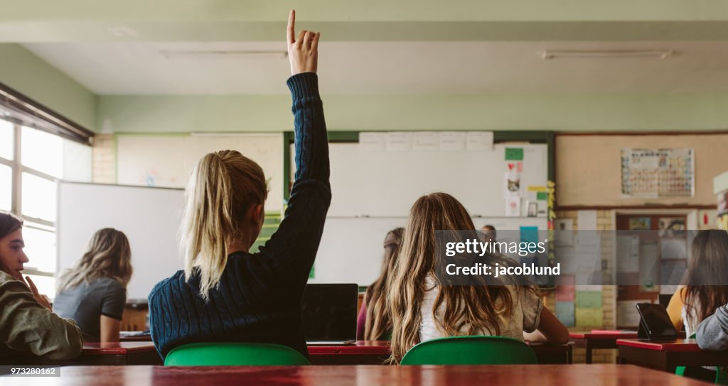 Student verhoogt hand en docent een vraag stelt