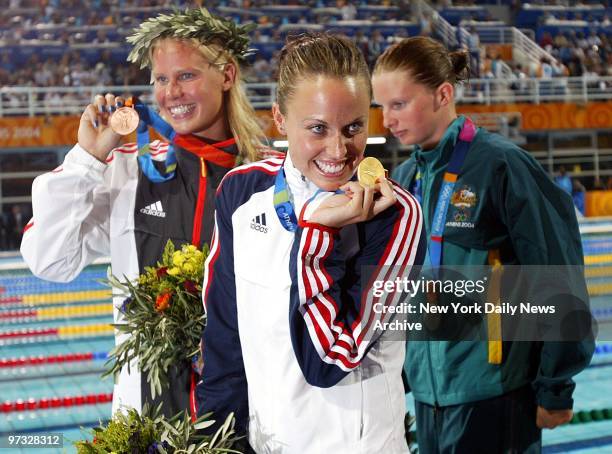 Swimmer Amanda Beard of the U.S. Shows off the gold medal she won in the 200-meter breaststroke at a medal ceremony in the Aquatic Center during the...