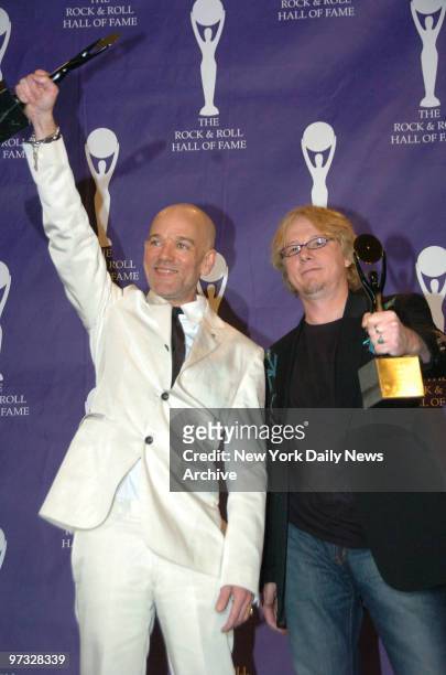 Michael Stipe and Mike Mills of REM clutch their statuettes as they take the stage in the press room at the Waldorf Astoria hotel during the 22nd...