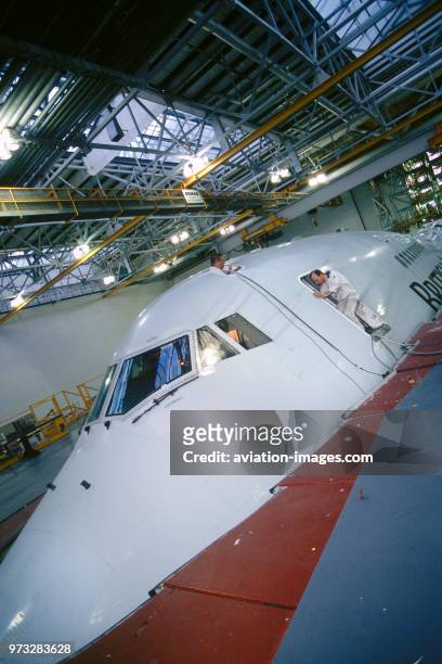Engineers working on a British Airways Boeing 747-400 in a maintenance hangar.