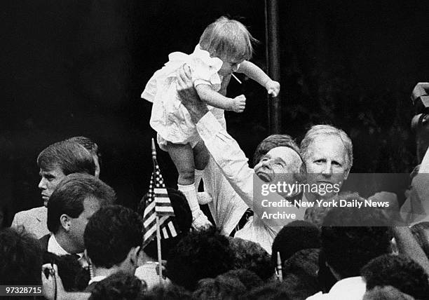 Vice President George Bush lifts baby in the air during campaign stop at the Annon Flag Company in Bloomfield.