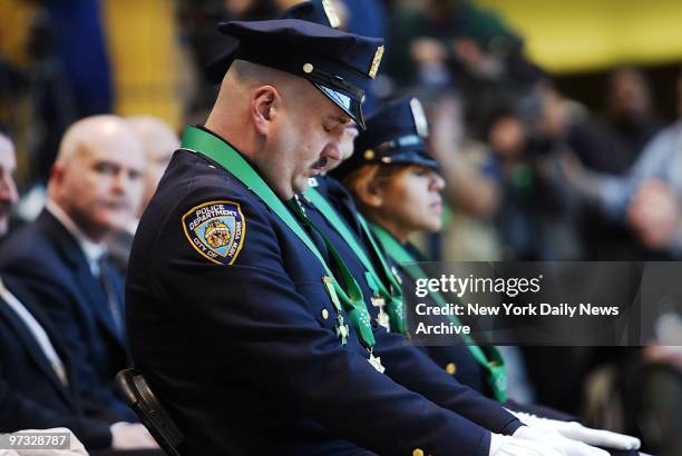 Detective Patrick McGee bows his head in memory of the victims of Sept. 11 during a ceremony at the Winter Garden in the World Financial Center....