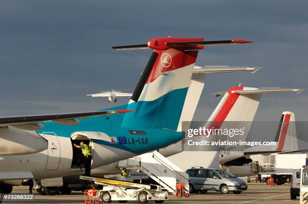 Tail-fins of Luxair Bombardier DHC-8 Dash 8-400 Q400 with CityJet BAE 146s and Fokker F-50 parked at London City.