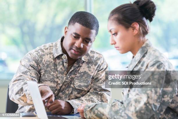 army soldiers review something together on laptop - military inspection stock pictures, royalty-free photos & images