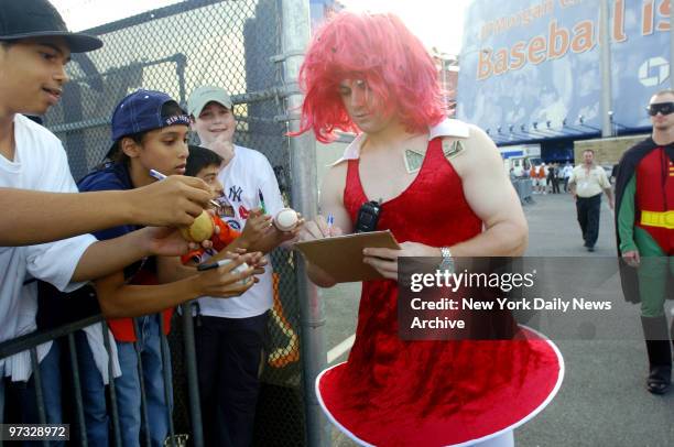 New York Mets' David Wright signs fans' autographs while wearing a dress and red wig during Mets Annual Rookie hazing event following a 3-2 win over...