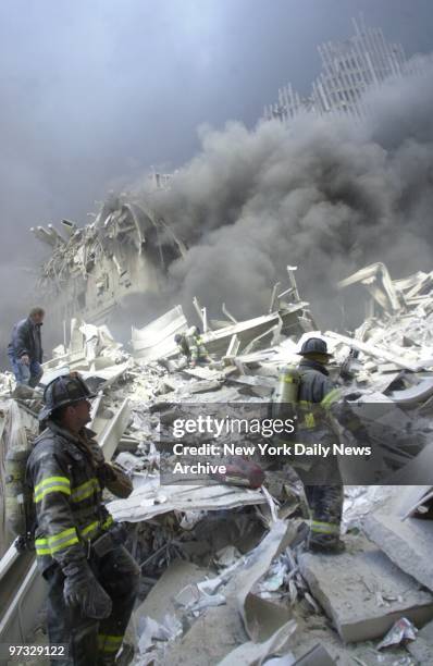 Firefighters look for survivors in the rubble of the World Trade Center after it was struck by a commercial airliner in a terrorist attack. A...