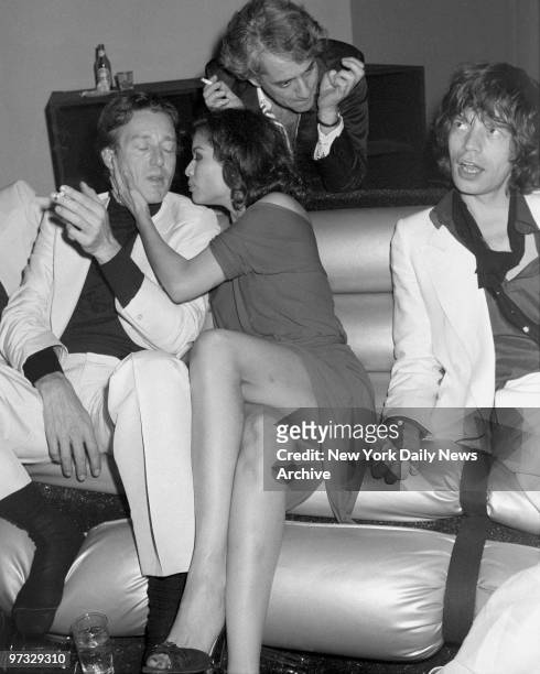 Mick Jagger looks unconcerned as his wife, Bianca, snuggles up to designer Halston during Bianca's birthday bash at Studio 54 in the wee hours of the...