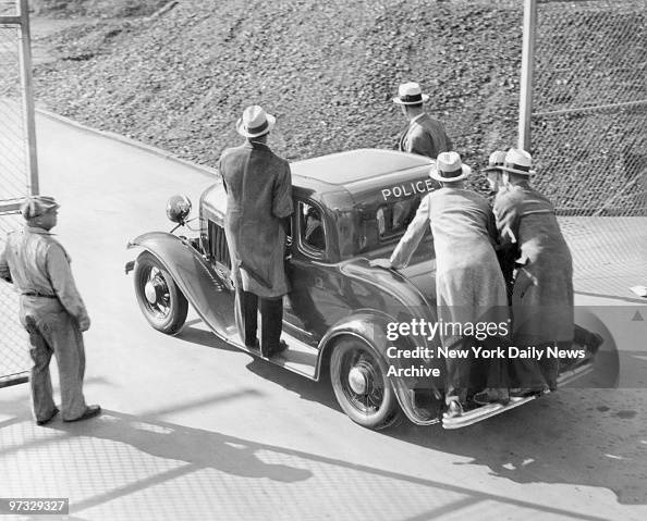 Detectives pile aboard a police car to rush to the scene of 