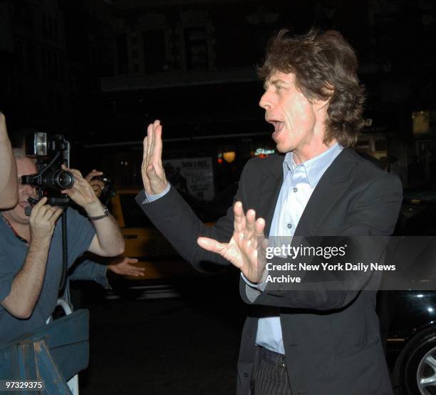 Mick Jagger waves to the throng of photographers outside the Village East Cinemas as he arrives for the New York premiere of the movie "The Man From...