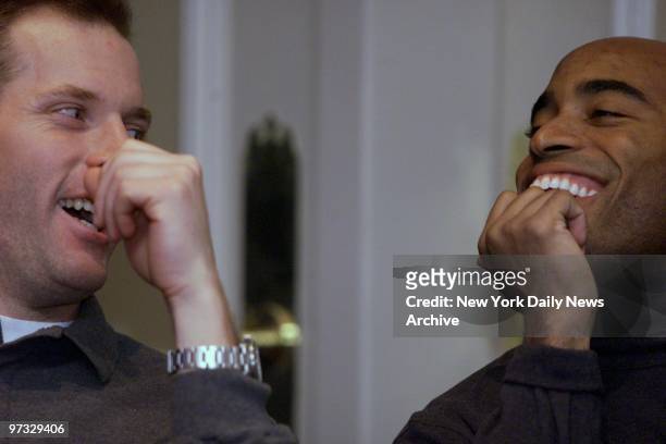 Kerry Collins and Tiki Barber of the New York Giants goof around while waiting to speak at a news conference regarding the NFC Championship game on...
