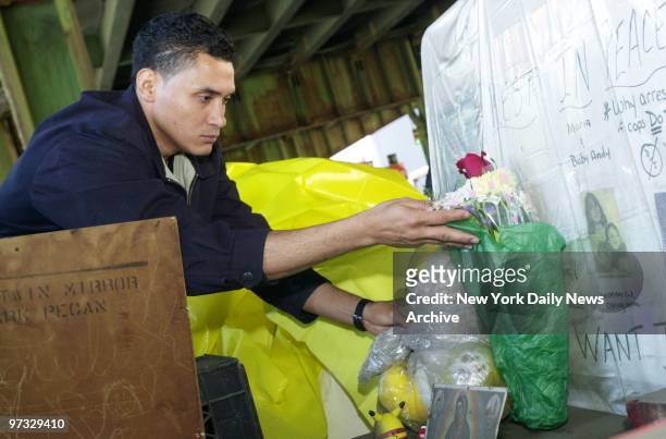 Victor Herrera puts flowers at a shrine in Sunset Park where his wife, children and sister-in-law were killed by an allegedly drunk police officer...