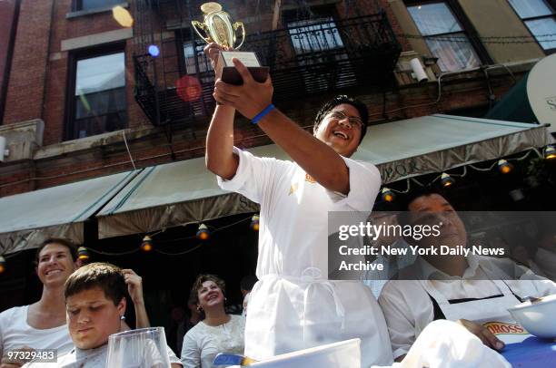 Victor Quontuna of Sorrento Ristorante, holds his championship trophy aloft as he exults after winning the 4th annual Tuttorosso Pasta Eating...