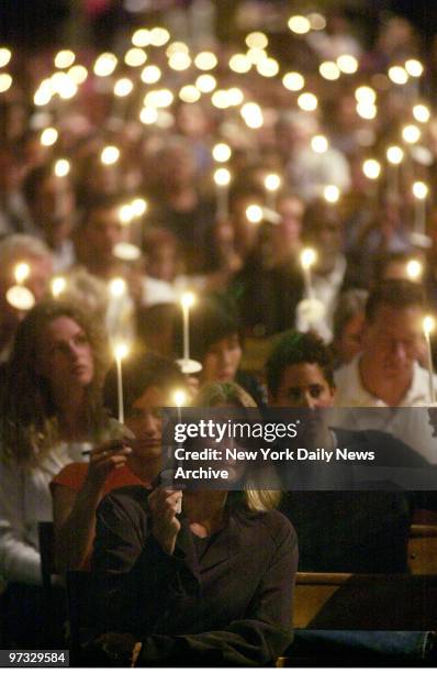 People mourn for the victims of the World Trade Center terrorist attack during a candlelight vigil at the Cathedral Church of St. John the Divine in...