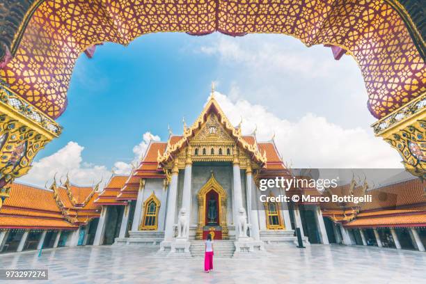 solo traveller woman walking inside the wat benchamabophit temple, bangkok - bangkok stock-fotos und bilder