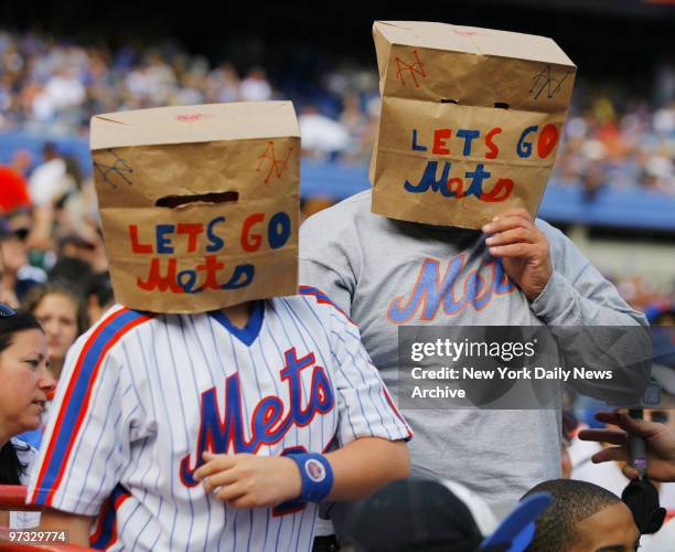 New York Mets' fans, wearing paper bags over their heads, still cheer on their team during a game against the Florida Marlins at Shea Stadium. The...