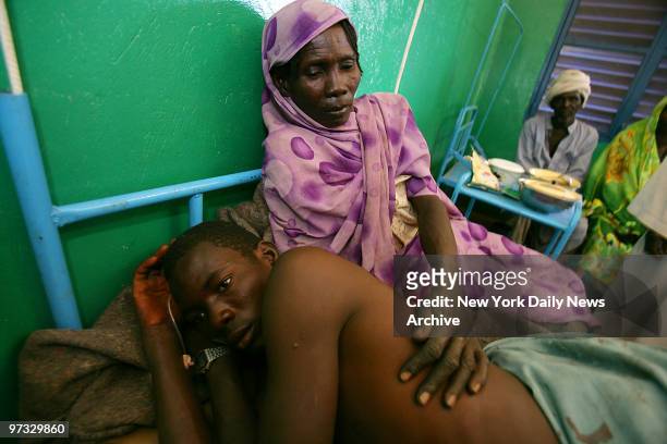 With his mother at his side, Haroun Mahamat recovers in Goz Beida Hospital in Chad, from bullet wounds inflicted by Arab militia men known as...