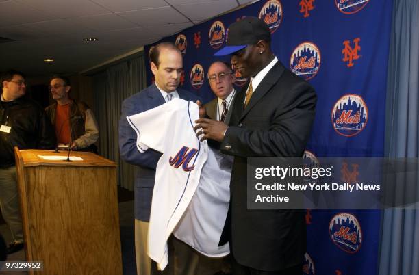 New York Mets' general manager Jim Duquette presents a jersey and cap to Mike Cameron, the team's new center fielder, at Shea Stadium.