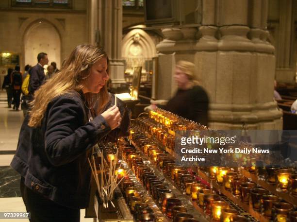 Worshiper lights candles during a special mass for the victims of the World Trade Center terrorist attack at St. Patrick's Cathedral. Thousands...