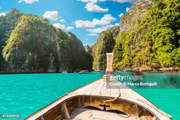 long tail boat at pileh lagoon, phi phi islands, thailand. - phi phi islands stock pictures, royalty-free photos & images