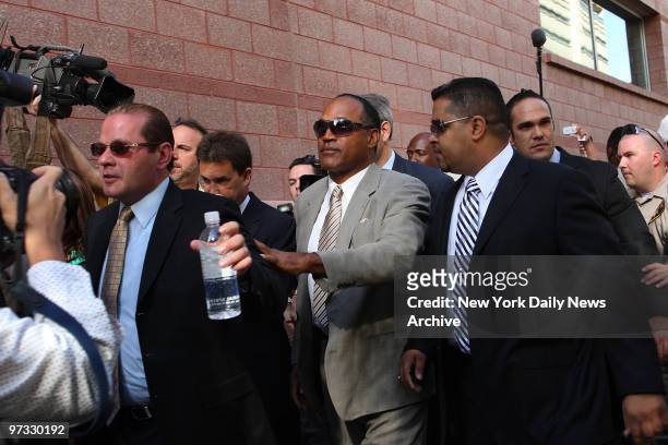 Simpson arrives at court in robbery case against him. Tom Scotto is on the far left.
