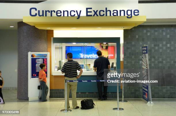 Passengers with bags at the Travelex currency exchange booth in the TerminalC.