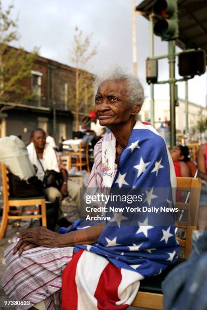Milvertha Hendricks sits wrapped in an American flag blanket outside New Orleans' Ernest N. Morial Convention Center as she waits with other...