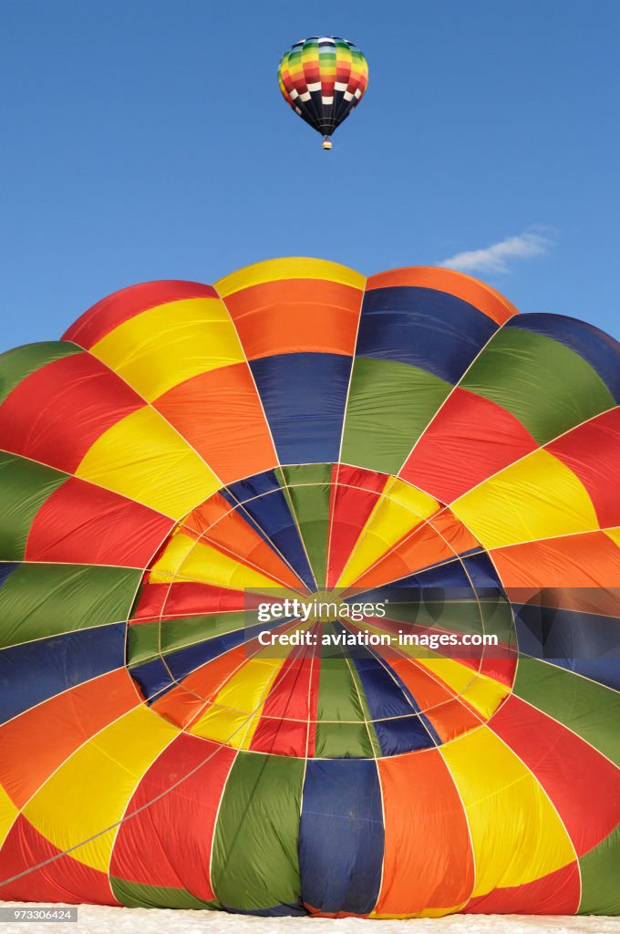 Top of the canopy and parachute of a Cameron A-120 with another hot-air balloon flying