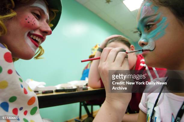 Wendy the Clown paints 7-year-old Tiffany Colon's face during the 4th annual Day of the Child celebration this afternoon in the Chelsea Piers Field...