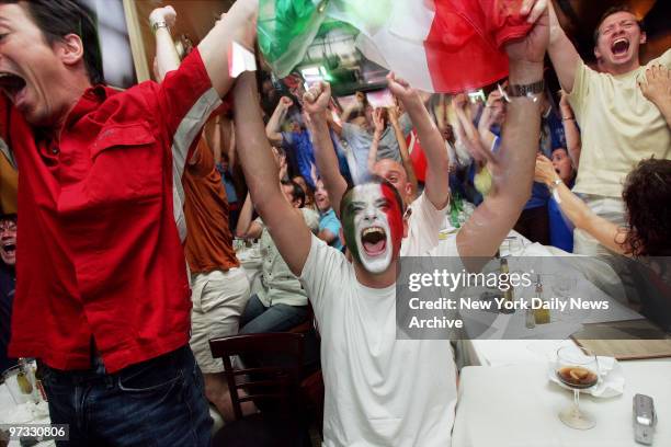 With his face painted to match the Italian flag, Sam Nadel, of Long Island, celebrates with other fans at Le Streghe restaurant in Soho as Italy...