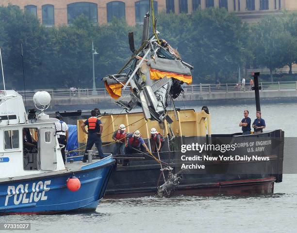 Scuba pulls out the helicopter from the Hudson River the morning after a crash between a helicopter and a small airplane killed nine people.