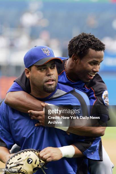 New York Mets' Jose Reyes jumps on the back of teammate Ramon Castro as he clowns around during batting practice at Yankee Stadium prior to a game...
