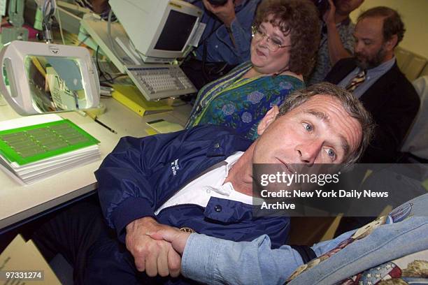 Texas Gov. George W. Bush, on a presidential campaign tour, greets a worker as he examines a printed circuit which the company manufactures at HABCO...