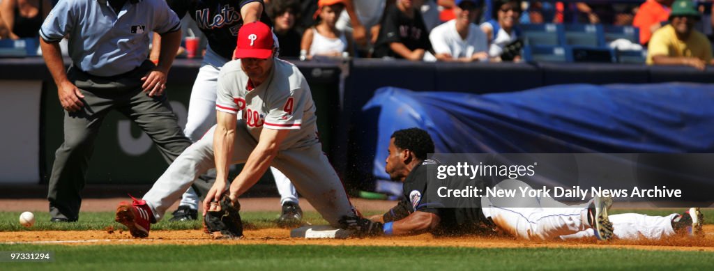 New York Mets' Jose Reyes slides into third on a triple as t