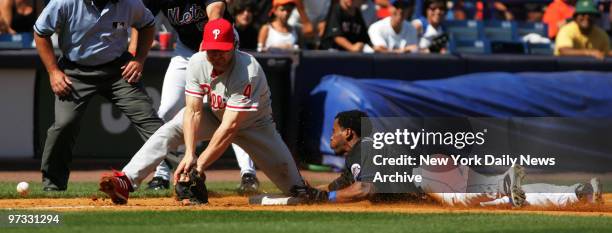 New York Mets' Jose Reyes slides into third on a triple as the ball gets by Philadelphia Phillies' David Bell in sixth inning action at Shea Stadium....