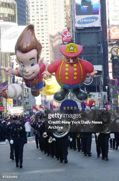 The New York Police Department Band marches through Times Square, followed by Jimmy Neutron and Harold the Fireman balloons, during the 76th annual...