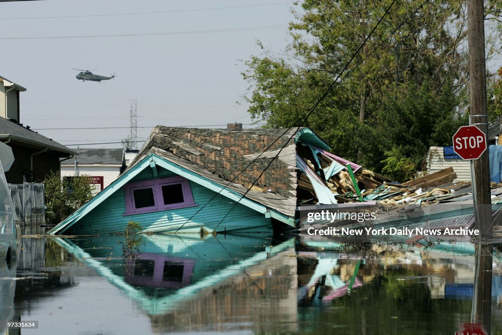 Military helicopter buzzes over the splintered remains of a 