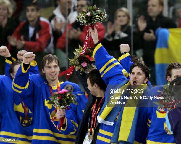 Team Sweden goalie Henrik Lundqvist raises a bouquet in celebration of his team's 3-2 win over Finland in the 2006 Winter Olympics gold medal hockey...