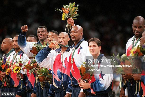 Team USA member Reggie Miller flashes his gold medal as he stands surrounded by other members of the United States men's basketball team during...