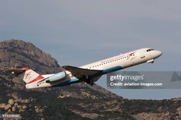 An Austrian Arrows Fokker F-100 undercarriage retracting climbing out after take-off.